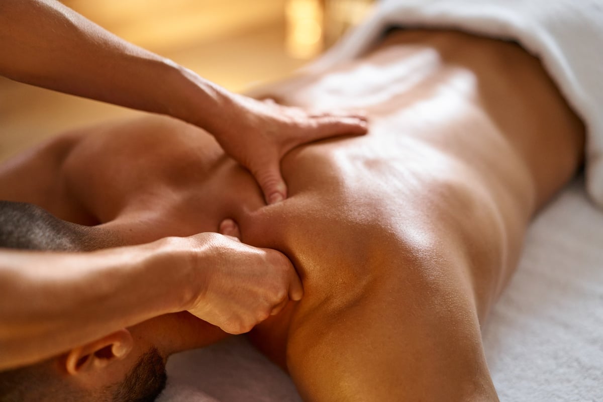 Physiotherapist performing hands-on soft tissue treatment on a patient's back