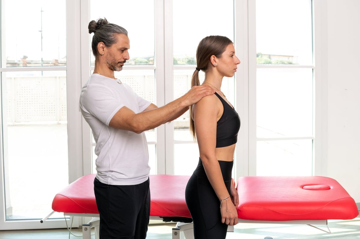 Physiotherapist performing a postural and spinal alignment assessment