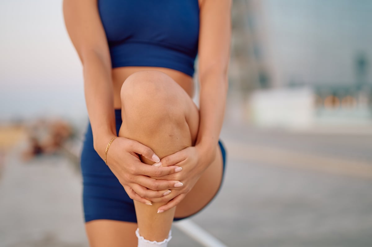 Athlete holding their knee after a sports injury during training