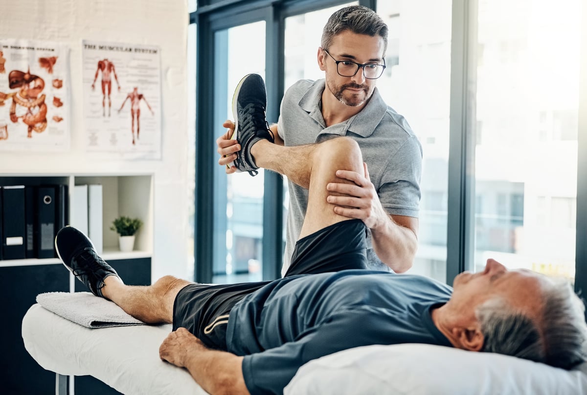 Physiotherapist guiding a patient through a rehabilitation exercise in a bright clinic